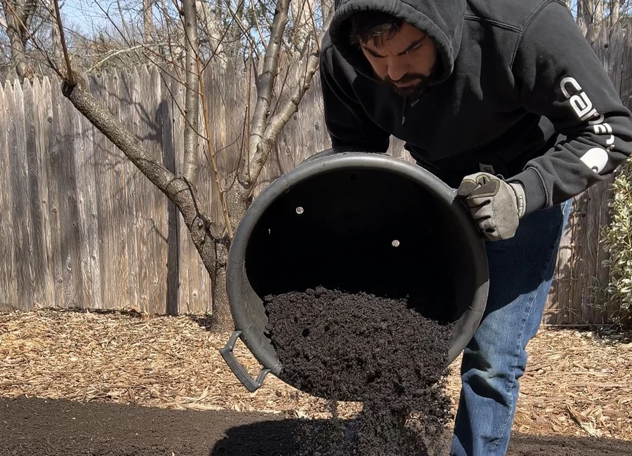 Adding finished compost to a garden bed